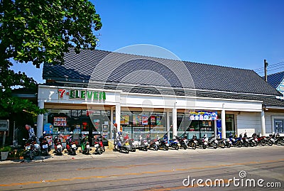 White retro facade building of 7 eleven convenience stores with a row of motorcycles at the front. Editorial Stock Photo